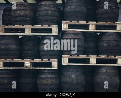 Righe di pallet con giocò il vecchio grunge vintage rovere scuro legno Barili di birra artigianale a magazzino della fabbrica di birra Foto Stock