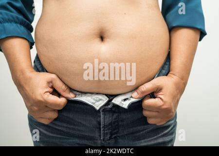 Il sovrappeso donna asiatica mostrano il grasso ventre presso l'ufficio. Foto Stock