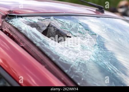 Primo piano di un'auto con un parabrezza rotto dopo un incidente fatale. Conseguenza di un incidente stradale fatale. Pericolo di automobile. Guida pericolosa e sconsiderata. Veicolo dopo un incidente con un pedone. Foto Stock