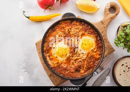 Shakshuka, uova fritte in salsa di pomodoro. Uova fritte tradizionali mediterranee. Cucina israeliana. Foto Stock
