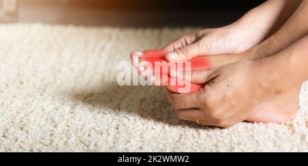 Donna asiatica tiene la sua ferita della punta che sente dolore il suo piede nel paese Foto Stock