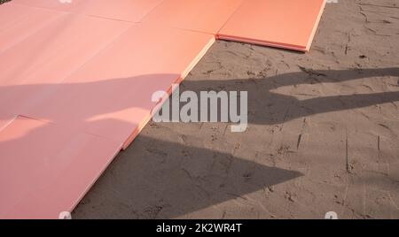 La lastra di polistirene polyplex è posata su sabbia bagnata come isolante per la fondazione di una piscina esterna Foto Stock