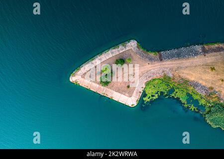 Ramificazione del fiume. Un albero fatto di pietre a forma di freccia. Separazione del letto di fiume di fronte alla diga di acqua. Isola a forma di freccia. Foto aerea. Foto Stock