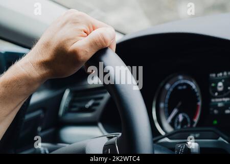 Mani maschili sul volante di un'auto Foto Stock