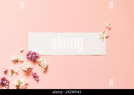 fiori lilla con cartellino bianco. Creative congratulazioni layout da lilla su carta bianca. Fiore di primavera concetto. Disposizione piatta, vista dall'alto, spazio di copia Foto Stock