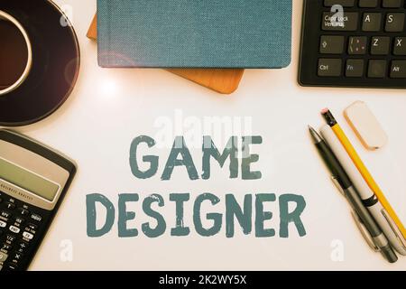 Scrittura a mano segno Game Designer. Word for Campaigner pixel Scripting Programmers console 3D Grafica Office fornisce su scrivania con tastiera e occhiali e tazza da caffè per lavorare Foto Stock