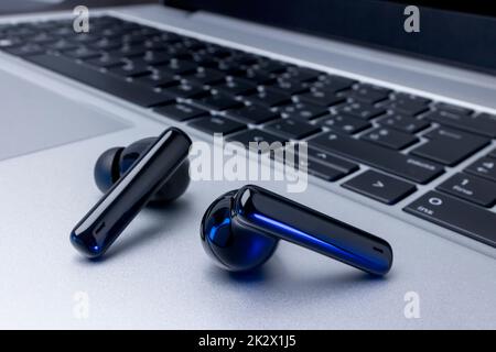 Cuffie wireless nere su computer portatile Foto Stock