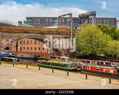 Barche a remi ormeggiate nello Staffordshire Arm del Bridgewater Canal con Castlefield Bowl in primo piano. Manchester, Regno Unito. Foto Stock