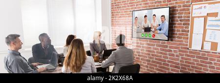 Un gruppo di imprenditori aventi Video conferenza nella sala riunioni Foto Stock