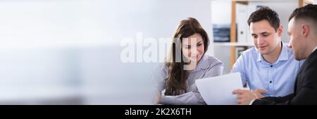 Advisor discutendo con coppia Foto Stock