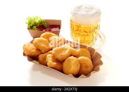 Pepite e birra sul tavolo bianco Foto Stock