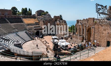 I turisti esplorano le antiche rovine dell'antico teatro greco durante le vacanze estive Foto Stock