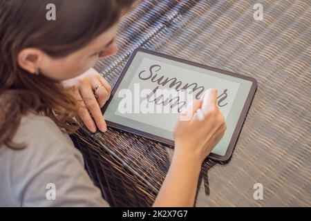 Calligrafer Young Woman scrive frase su tablet digitale. Iscrizione di lettere ornamentali decorate. Calligraphy, graphic design, lettering, graphic writing Foto Stock