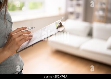 Donna che compila il modulo di valutazione del bene immobile Foto Stock