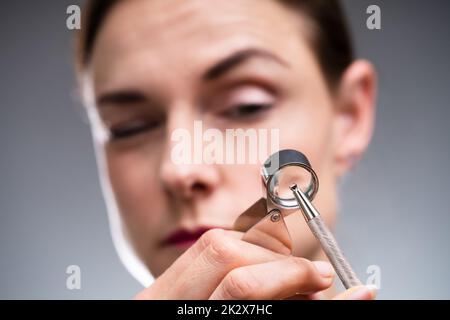 Gioielliere che guarda il diamante attraverso la lente d'ingrandimento Foto Stock