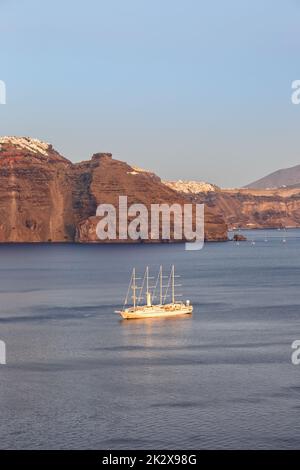 Nave a vela a Santorini vacanze isola in Grecia viaggio Mediterraneo sera Santorini in formato ritratto Foto Stock