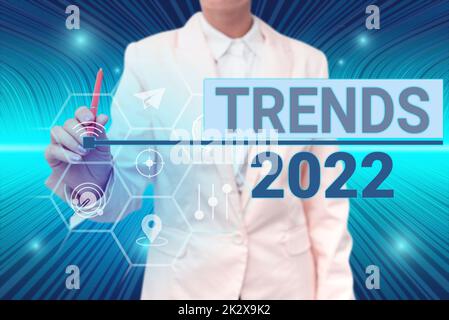 Didascalia di testo che presenta i trend 2022. Parola per la tendenza prevalente di anno imminente ampiamente discussa signora in linea nella penna che tiene il vestito simbolizzando le realizzazioni riuscite del lavoro di squadra. Foto Stock