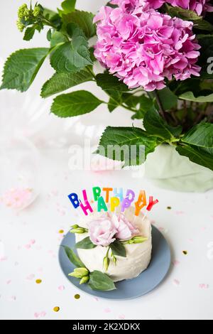 Bellissima torta bento, decorata con fiori di eustoma fresco sullo sfondo di dolci e l'iscrizione buon compleanno, palloncini, fiori. Concetto di vacanza. Foto Stock