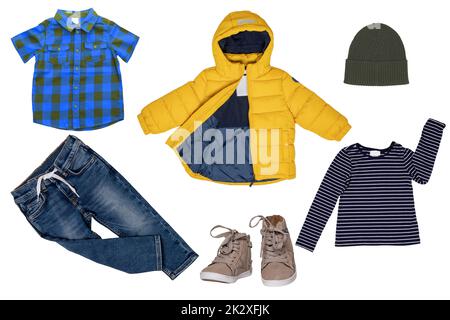 Collage Set di piccoli abiti primaverili isolati su sfondo bianco. Pantaloni o pantaloni denim, sneaker, giacca impermeabile, camicie e berretto per bambino. Moda estiva per bambini. Foto Stock