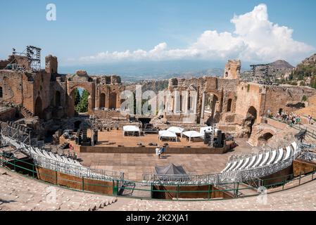 Turisti che esplorano le vecchie rovine del teatro greco durante le vacanze estive Foto Stock