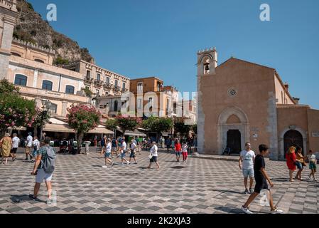 I turisti esplorano la vecchia piazza cittadina nell'antica città costiera durante l'estate Foto Stock