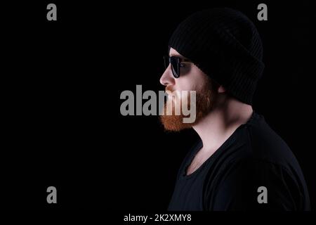 Uomo Barbuto in occhiali da sole e cappello Foto Stock