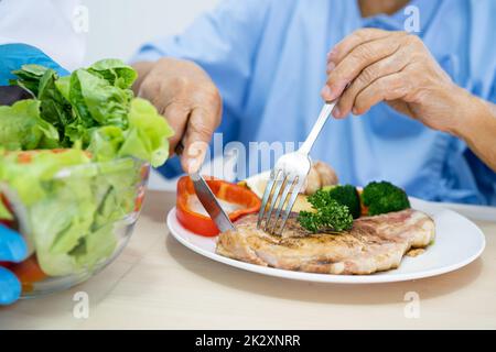 Paziente di mangiare cibo da ospedale sul vassoio da letto in reparto Foto  stock - Alamy