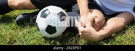 Maschio di giocatore di calcio che soffrono di lesioni del ginocchio Foto Stock