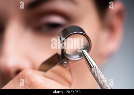 Gioielliere che guarda il diamante attraverso la lente d'ingrandimento Foto Stock