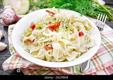 Fettuccine con zucchine e peperoni in tavola su asse di legno Foto Stock