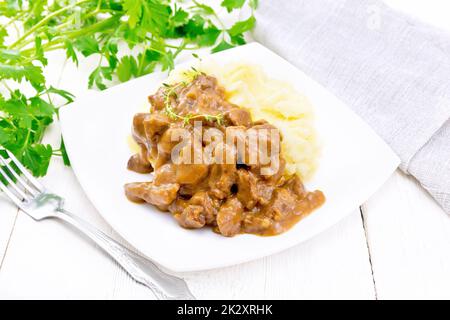 Gulasch di manzo con purè di patate in piatto su lavagna bianca Foto Stock