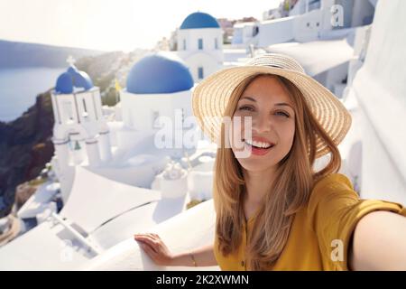 Ispanica bella donna di moda che prende autoritratto al tramonto a Santorini Island, Grecia Foto Stock