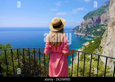 Turismo a Capri. Giovane bella donna di moda che gode di un paesaggio mozzafiato sull'isola di Capri, Italia. Foto Stock