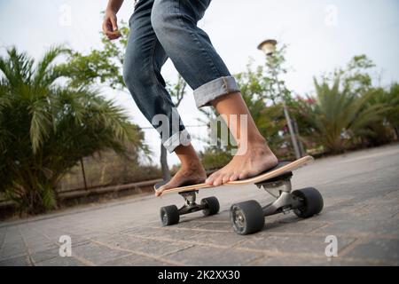 Ragazza su skateboard a piedi nudi Foto Stock