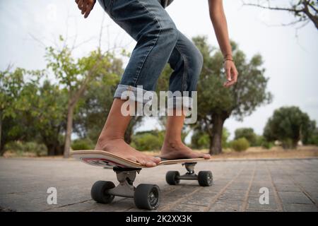 Ragazza su skateboard a piedi nudi Foto Stock