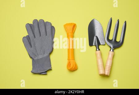 Attrezzi da giardino per la lavorazione di letti in giardino su sfondo verde Foto Stock