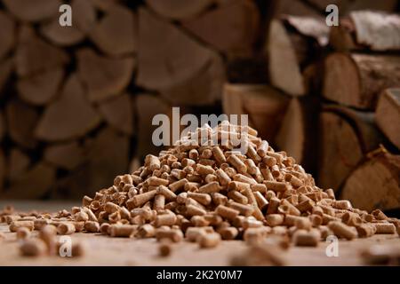 Pila di pellet di legno vicino pila di legna da ardere in luce del giorno Foto Stock