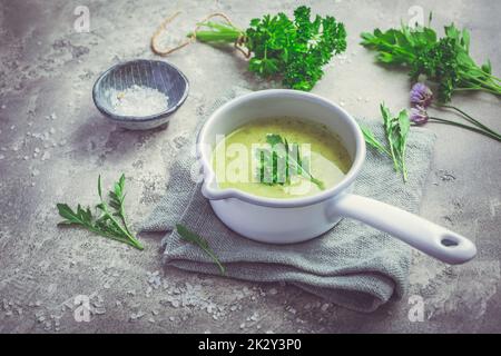 Sana zuppa di erbe verdi fatta in casa in pentola a base di erbe locali selvatiche e da giardino Foto Stock