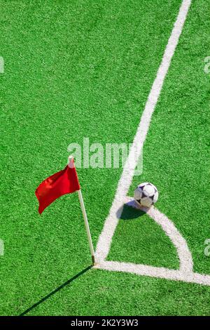 Bandiera d'angolo e palla di calcio al campo di calcio Foto Stock