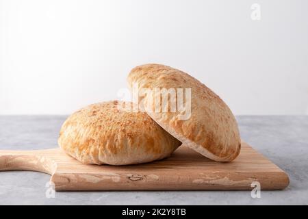 Parlenka, pane piatto bulgaro su tagliere di legno su sfondo neutro con spazio copia Foto Stock