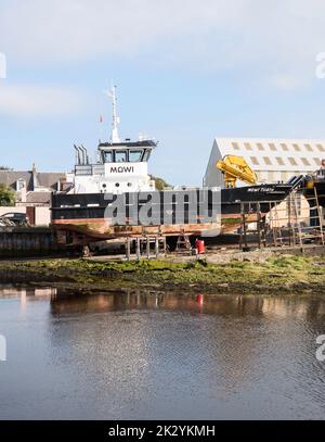 La nave di sostegno all'allevamento del salmone Mowi Tuath, sulla via di scorrimento degli ingegneri marini Alexander Noble & Sons, nel porto di Girvan, nel South Ayrshire, Scozia, Regno Unito Foto Stock