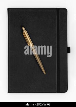 Notebook in pelle nera di qualità con penna dorata sulla parte superiore, isolato su sfondo bianco Foto Stock