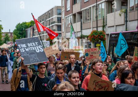 Circa duecento giovani manifestanti sono visti camminare per il centro della città mentre si tengono cartelli durante la dimostrazione. Studenti e giovani provenienti da tutte le parti del paese si sono riuniti nella città olandese di Arnhem per chiedere un intervento sulle richieste delle comunità indigene, nere e di altre comunità emarginate per riappropriarsi delle loro terre. La giovane organizzazione climatica #FridaysForFuture ha organizzato questo marzo per continuare a chiedere una migliore politica climatica e per fermare la distruzione delle terre di MAPA (popolazioni e aree più colpite). Foto Stock