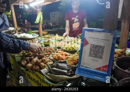 Giacarta Sud, Giacarta, Indonesia. 23rd Set, 2022. Un venditore di strada che fornisce un sistema di pagamento con codice QR sta servendo un acquirente. Il sistema di pagamento del codice di risposta rapida (QR) sarà integrato in 5 paesi ASEAN: Indonesia, Malaysia, Thailandia, Singapore, E le Filippine, il cui obiettivo di realizzazione è il 2022 novembre, come PERRY WARJIYO, il governatore della Banca Indonesia il 2022 luglio. (Credit Image: © Dicky Bisinglasi/ZUMA Press Wire) Credit: ZUMA Press, Inc./Alamy Live News Foto Stock