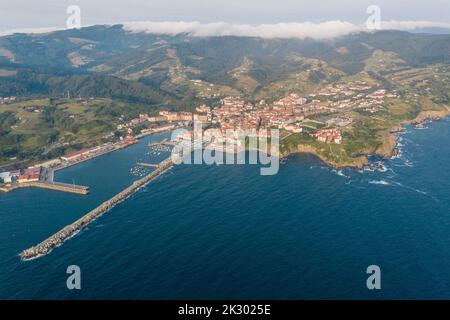 Veduta aerea della bellissima storica cittadina di pescatori di Bermeo, al tramonto. Barche ormeggiate nel porto. Vista panoramica della città. Foto Stock