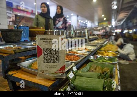 Giacarta Sud, Giacarta, Indonesia. 23rd Set, 2022. Un venditore di strada che fornisce un sistema di pagamento con codice QR sta servendo un acquirente. Il sistema di pagamento del codice di risposta rapida (QR) sarà integrato in 5 paesi ASEAN: Indonesia, Malaysia, Thailandia, Singapore, E le Filippine, il cui obiettivo di realizzazione è il 2022 novembre, come PERRY WARJIYO, il governatore della Banca Indonesia il 2022 luglio. (Credit Image: © Dicky Bisinglasi/ZUMA Press Wire) Credit: ZUMA Press, Inc./Alamy Live News Foto Stock