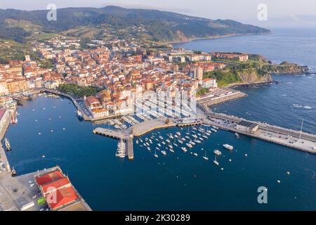 Veduta aerea della bellissima storica cittadina di pescatori di Bermeo, al tramonto. Barche ormeggiate nel porto. Vista panoramica della città. Foto Stock