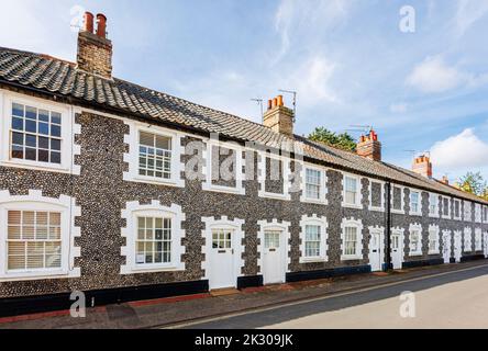 Terrazza di case di stile architettonico locale con pareti in pietra selce a Holt, una piccola città storica mercato georgiano nel nord Norfolk, Inghilterra Foto Stock