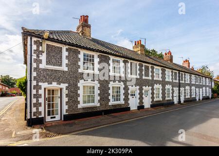 Terrazza di case di stile architettonico locale con pareti in pietra selce a Holt, una piccola città storica mercato georgiano nel nord Norfolk, Inghilterra Foto Stock