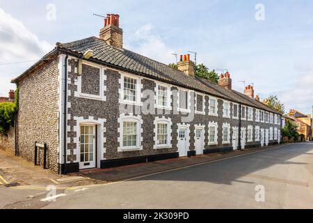 Terrazza di case di stile architettonico locale con pareti in pietra selce a Holt, una piccola città storica mercato georgiano nel nord Norfolk, Inghilterra Foto Stock